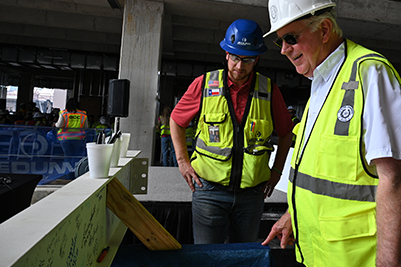Topping Out - Mike Novak reviews the signing beam.