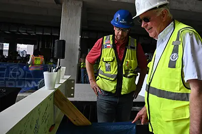 Topping Out - Mike Novak reviews the signing beam.