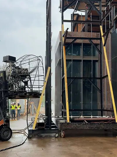 Water simulating a heavy storm is blown directly at the performance mock-up during water Infiltration testing, 2025